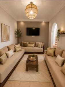 a living room with two couches and a table at Rayhane-26 in Al Ghar