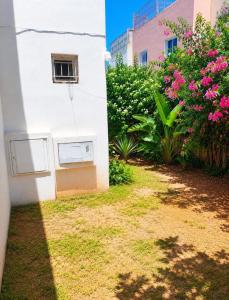 a white building with a window and some flowers at Rayhane-26 in Al Ghar