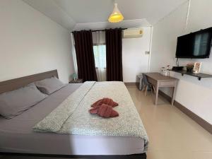 a bedroom with a bed with a stuffed animal on it at Collection O Ayothaya Hotel in Phra Nakhon Si Ayutthaya