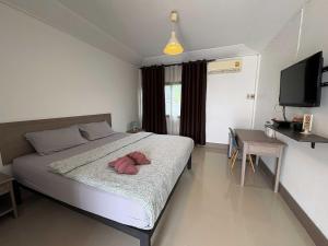a bedroom with a bed with a television and a table at Collection O Ayothaya Hotel in Phra Nakhon Si Ayutthaya