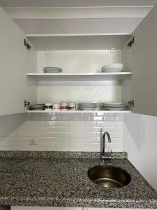 a kitchen counter with a sink and plates on shelves at Hamsiköy Doruk Apart in Macka