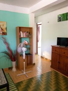 a living room with a floor fan and a book shelf at Appartement confortable à Sainte-Anne, 70m², vue jardin in Sainte-Anne
