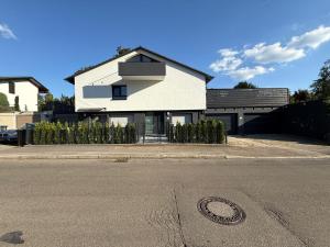 a white house sitting on the side of a street at Cozy & small apartment-Böblingen in Böblingen