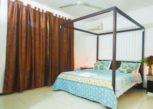 a bedroom with a canopy bed in a room at Modern Apartment in Pereybere + Pool in Pereybere
