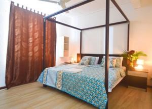 a bedroom with a canopy bed in a room at Modern Apartment in Pereybere + Pool in Pereybere