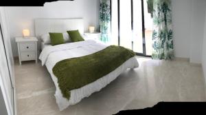 a bedroom with a large bed with a green blanket at Spacious Apartment with Views in Málaga, 77 m², Shared Pool in San Luis de Sabinillas