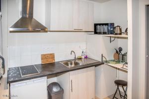 a kitchen with white cabinets and a sink at Studio confortable à Abondant, 30 m² avec jardin équipé in Abondant