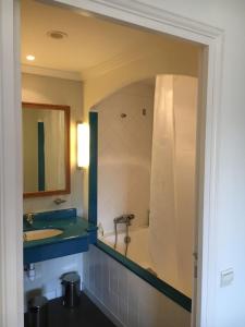 a bathroom with a tub and a sink and a mirror at Appartement cosy à Saint-André-des-Eaux de 47 m² avec jardin in Saint-André-des-Eaux +9 photos