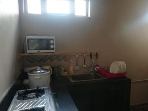 a kitchen with a sink and a tv on the wall at Modern Apartment with Garden and Lake View in Riambel in Riambel