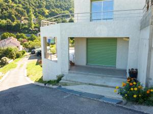 a house with a green garage door on the side of it at Maison confortable avec vue sur la mer et la montagne à Oletta. in Oletta