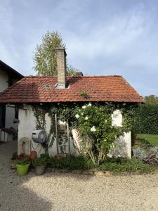 a small white house with a red roof at Studio - Le Saule in Foissiat