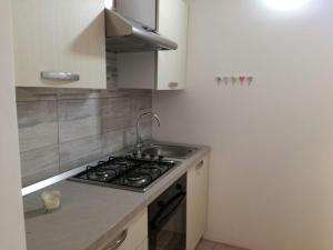 a small kitchen with a stove and a sink at Comfortable Villa in Ragusa with Pool in Trecasuzze