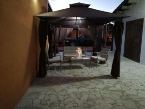 a patio with a table and chairs under an umbrella at Comfortable Villa in Ragusa with Pool in Trecasuzze +18 photos