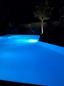 a pool with blue lights in the dark at Comfortable Villa in Ragusa with Pool in Trecasuzze