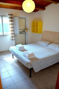 a bedroom with a bed with towels on it at Comfortable Villa in Ragusa with Pool in Trecasuzze