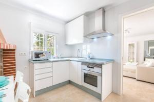 a white kitchen with a sink and a stove at Charming Villa in Competa with Private Pool in Cómpeta