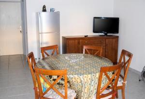 a dining room table with chairs and a refrigerator at Appartement face à la mer à La Trinité – 70 m² – Terrasse in La Trinité