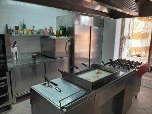 a kitchen with a stove and a stainless steel refrigerator at Spacious villa with private pool and stunning views in Bompensiere