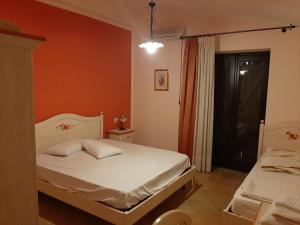 a bedroom with two beds and an orange wall at Spacious villa with private pool and stunning views in Bompensiere