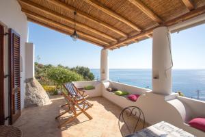 a balcony with chairs and a view of the ocean at House with garden and sea view in Lipari in Lipari
