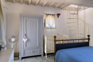 a bedroom with a blue bed and a crib at Charming House in Trequanda with Shared Pool in Trequanda
