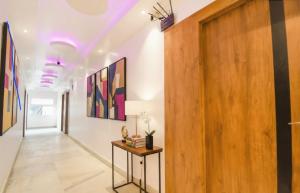 a hallway with paintings on the walls and a wooden door at The Golden Plaza in Tarapith +17 photos
