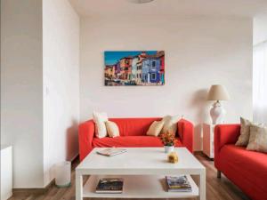 een woonkamer met een rode bank en een tafel bij Apartamento Playamar in Torremolinos