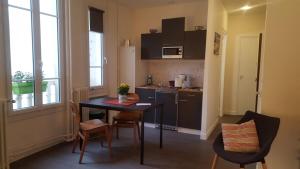 a small kitchen with a table and chairs in a room at Charmant Studio à 2pas du Château de Vincennes in Vincennes
