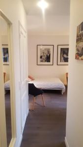 a room with two beds and a chair in it at Charmant Studio à 2pas du Château de Vincennes in Vincennes