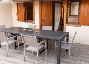 a black table with chairs and a bottle of beer on it at Chalet confortable à Giffaumont-Champaubert avec terrasse in Giffaumont-Champaubert