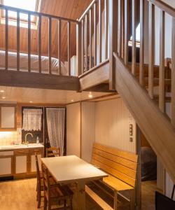 a kitchen and dining room with a table and stairs at Chalet confortable à Giffaumont-Champaubert avec terrasse in Giffaumont-Champaubert