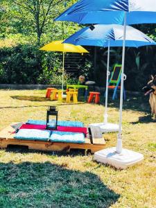 a bed with an umbrella on a table in the grass at House with Shared Pool in Águeda, Mountain View in Urgueira +55 photos