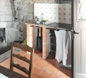 a kitchen with a table and a sink in a room at House with Shared Pool in Águeda, Mountain View in Urgueira