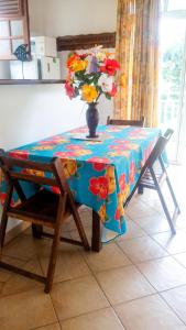 a table with a vase of flowers on top of it at Appartement confortable au Robert 70 m² avec jardin privé in Le Robert