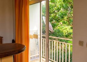 a sliding glass door with a view of a balcony at Appartement confortable au Robert 70 m² avec jardin privé in Le Robert