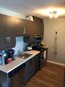 a kitchen with a sink and a stove top oven at Luxurious Apartment in Brossard with Terrace in Brossard