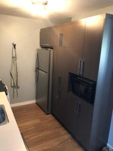 a kitchen with a stainless steel refrigerator and cabinets at Luxurious Apartment in Brossard with Terrace in Brossard