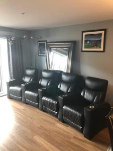 a waiting room with black leather chairs and a couch at Luxurious Apartment in Brossard with Terrace in Brossard +4 photos