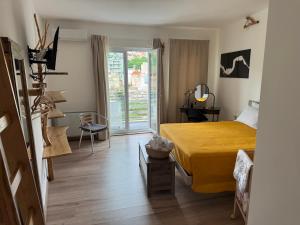a bedroom with a yellow bed and a balcony at Mamma Adelina in Enna