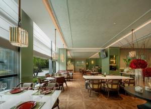 a restaurant with tables and chairs in a room at 杭州钱江新城黄龙璀怡酒店 凯悦尚选 in Hangzhou