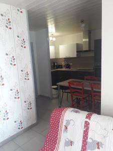 a room with a kitchen and a table with chairs at Appartement cosy avec piscine privée à Métabief - 38 m² in Métabief