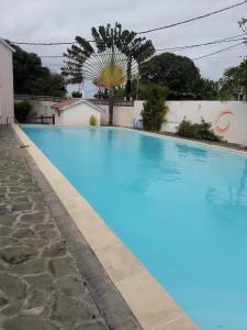 a large blue swimming pool next to a building at Modern Apartment in Melville, Pool View, 120 m² in Grande Gaube