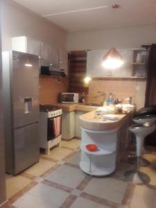 a kitchen with a sink and a refrigerator at Modern Apartment in Melville, Pool View, 120 m² in Grande Gaube +5 photos