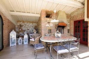 a patio with a table and chairs and a brick wall at Charming House in Trequanda + Pool in Trequanda