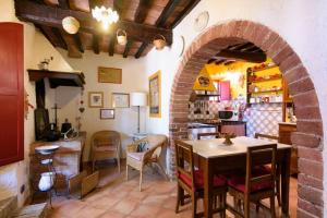 a kitchen with a table and a brick archway at Charming House in Trequanda + Pool in Trequanda