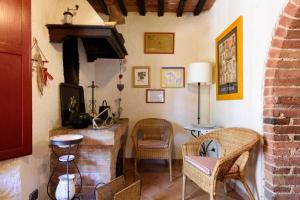 a living room with a stone fireplace and chairs at Charming House in Trequanda + Pool in Trequanda