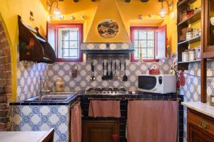 a kitchen with a stove and a microwave at Charming House in Trequanda + Pool in Trequanda +68 photos