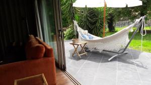 a patio with a hammock and a chair and a table at Beautiful villa in Póvoa de Lanhoso with pool and garden in Póvoa de Lanhoso