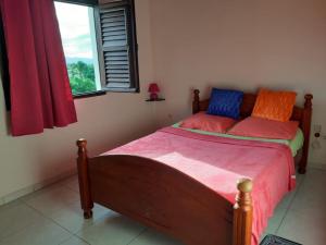 a bedroom with a bed with colorful pillows and a window at Appartement charmant à Sainte-Marie avec terrasse de 88 m² in Sainte-Marie