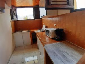 a small kitchen with a microwave on a counter at Appartement charmant à Sainte-Marie avec terrasse de 88 m² in Sainte-Marie